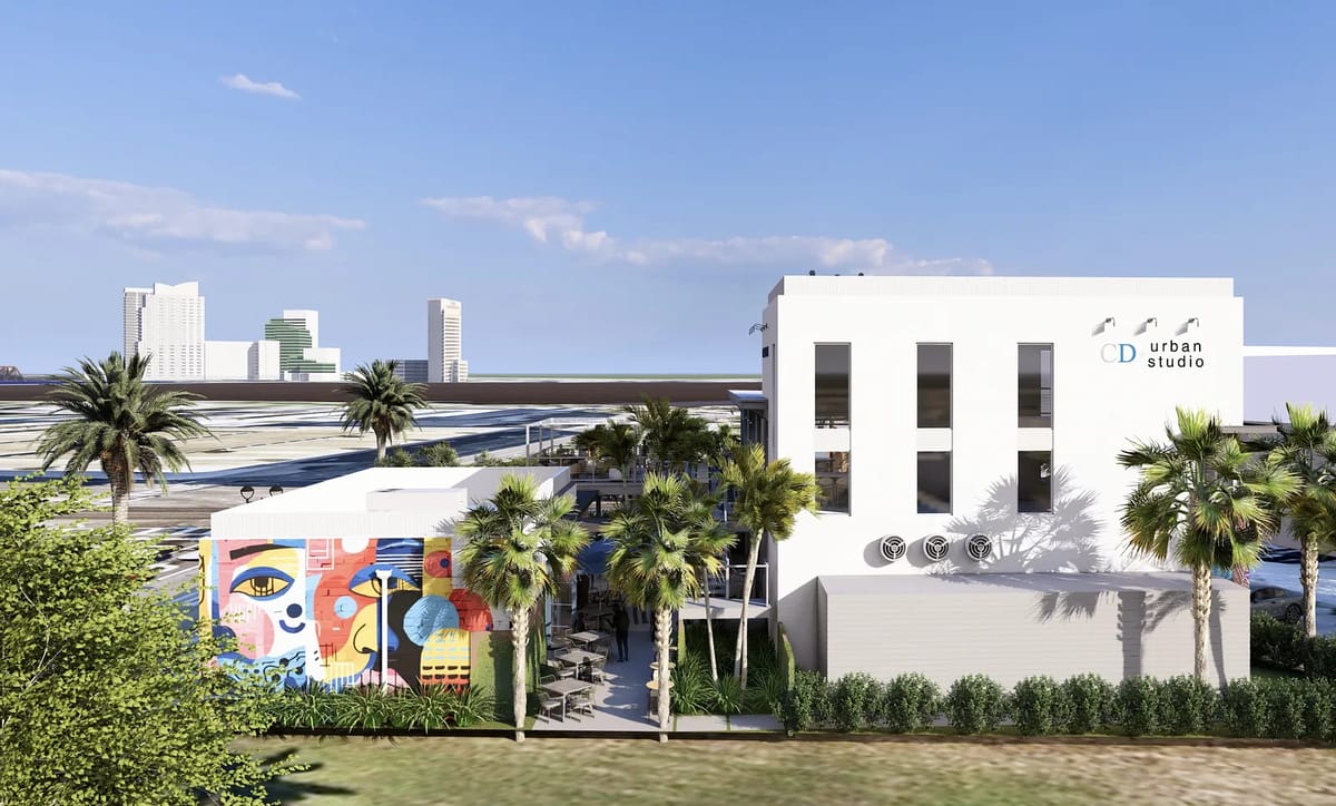 Exterior view of a modern building with white facade, colorful mural, and palm trees.