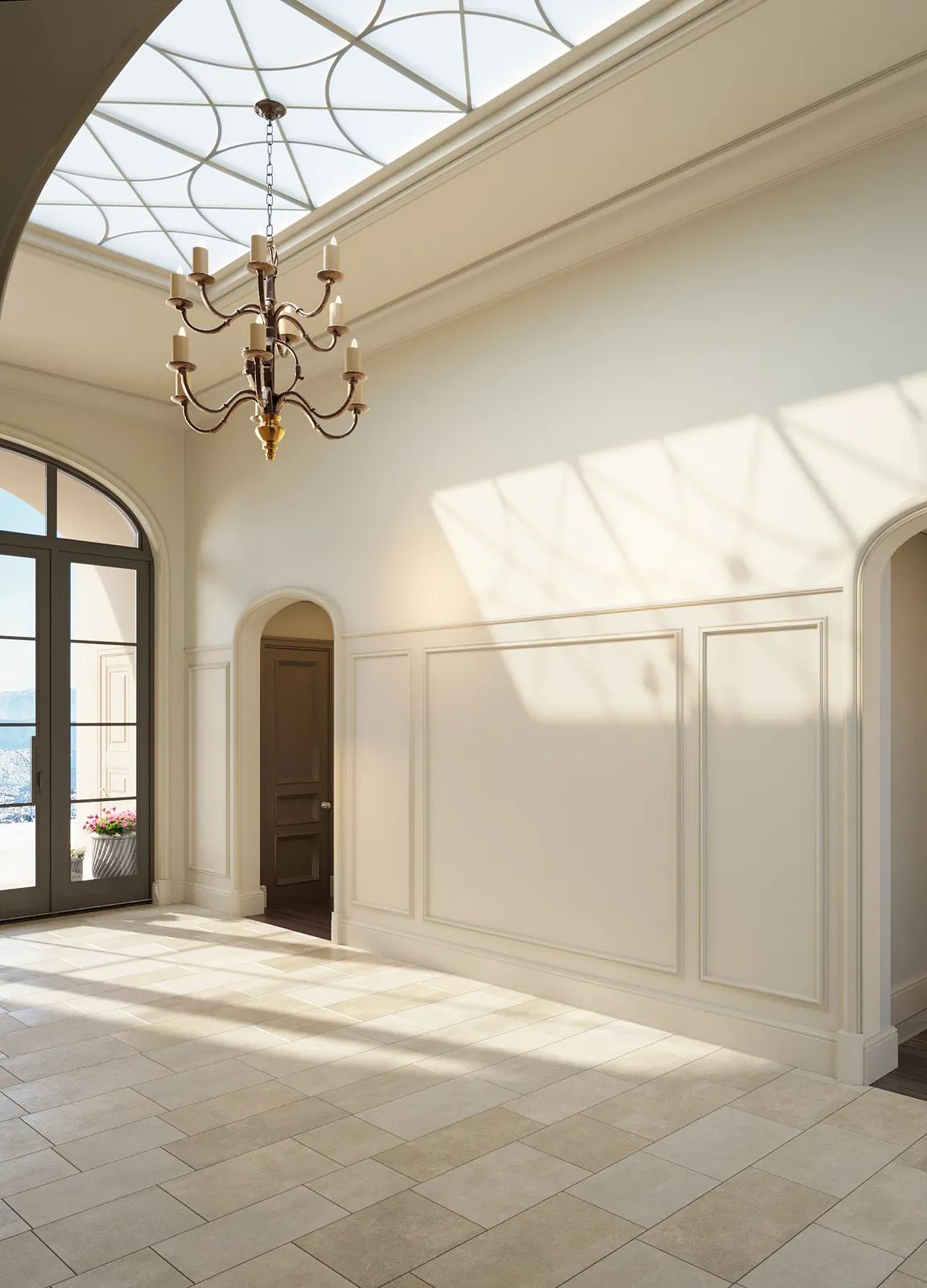 Foyer with chandelier, doorways, wainscoting, skylight, and neutral stone tile flooring.
