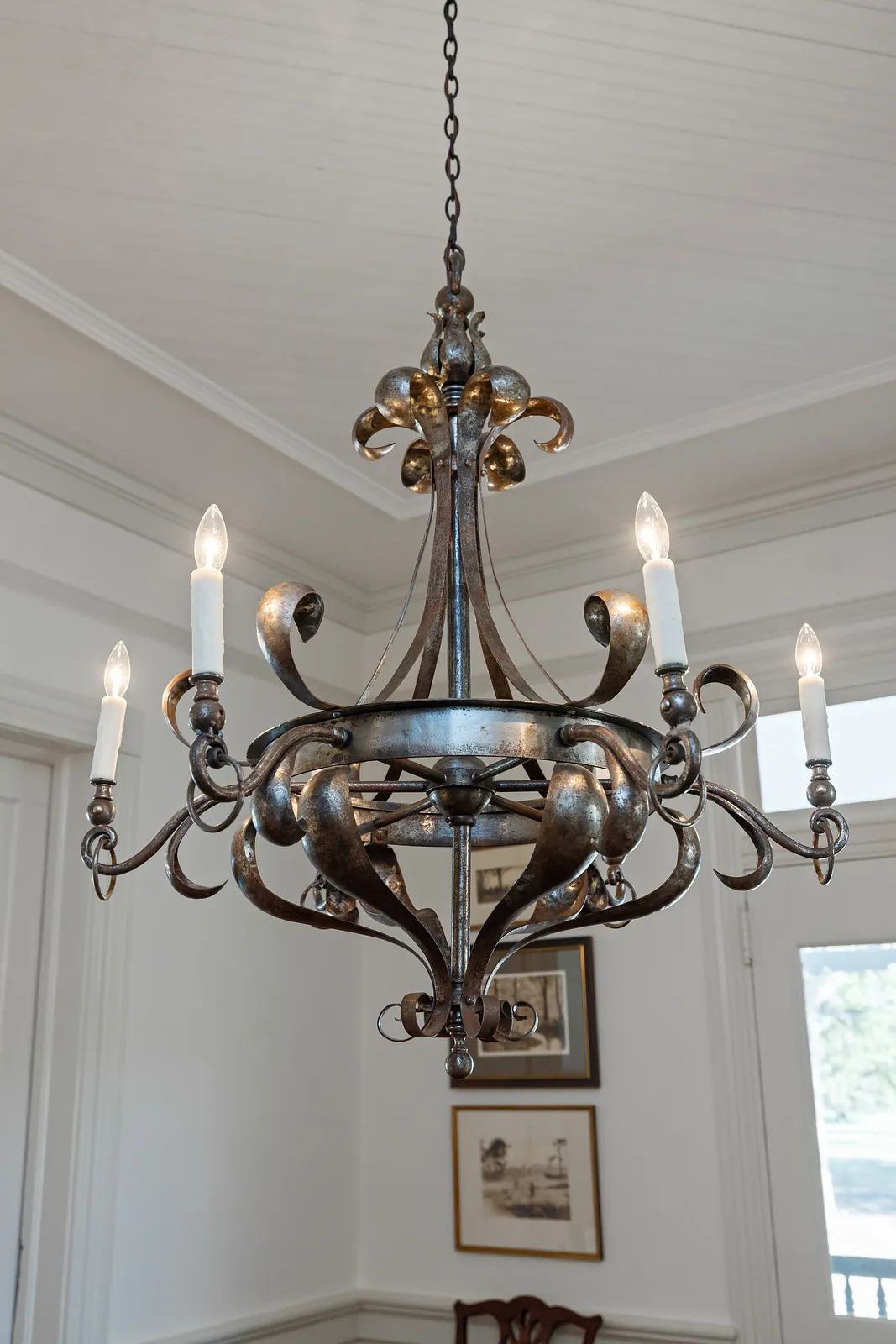Room with decorative chandelier and framed artwork on walls.