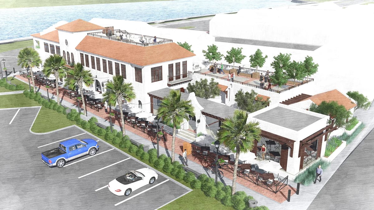 Exterior front view of a building with patio area, palm trees, and parked cars.
