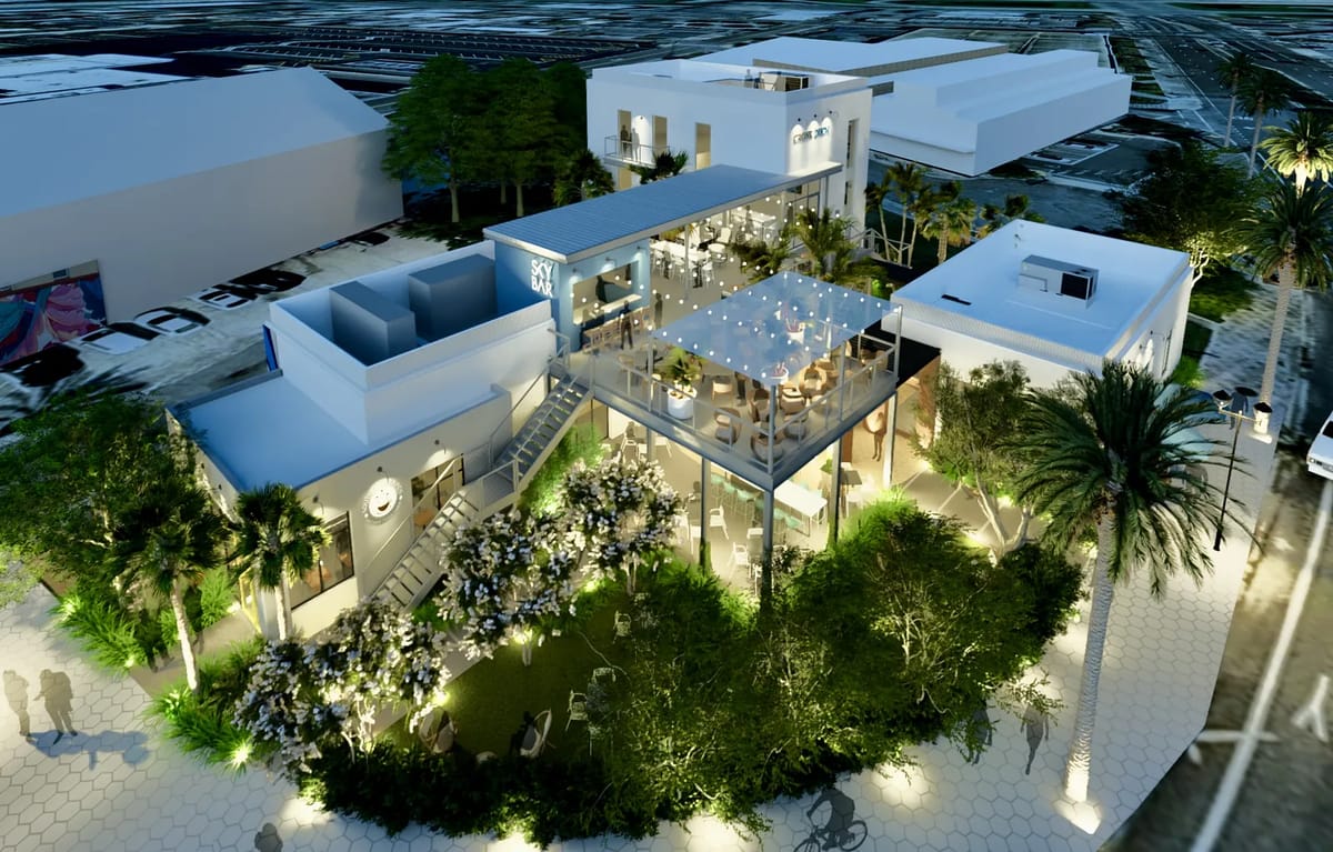 Exterior view of a modern building with gardens, patio, staircase, and large glass panels.