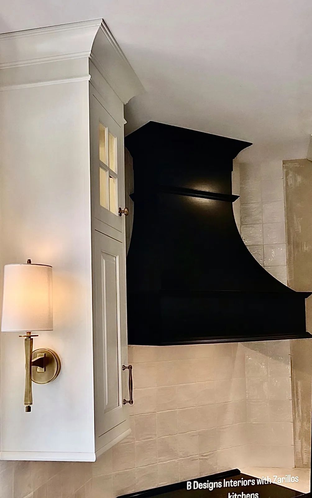 Perfect sconces and black, range hood in this French-inspired kitchen 