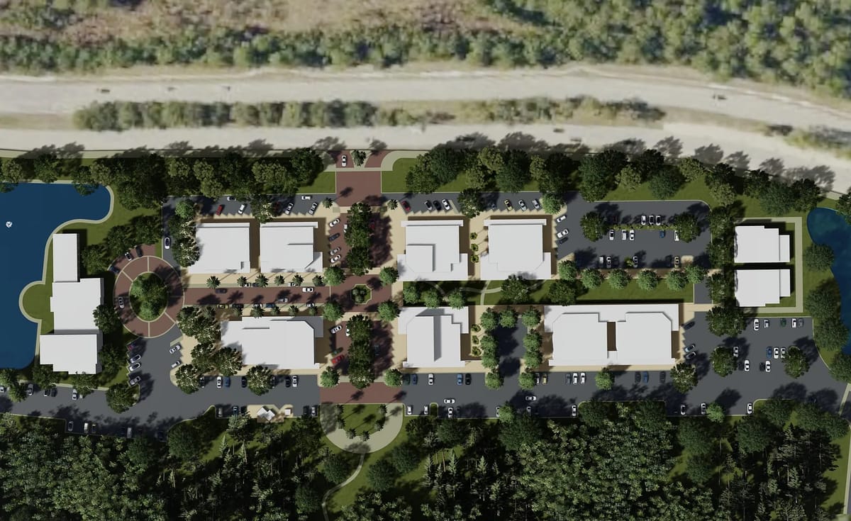 Aerial view of a residential development with multiple buildings and green landscaping.