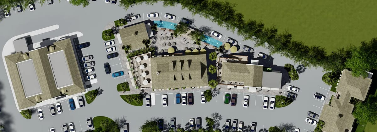 Aerial view of a developed site with buildings, parking lot, swimming pool, and landscaping.