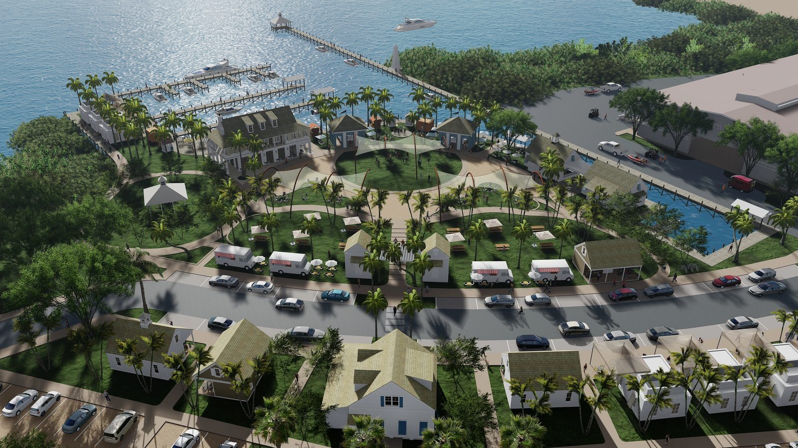 Aerial view of a waterfront development with buildings, trees, boats, and a circular pathway.