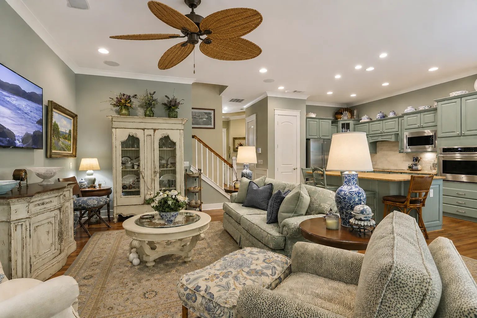 Living room with green cabinetry, circular coffee table, area rug, sofas, and decorative items.