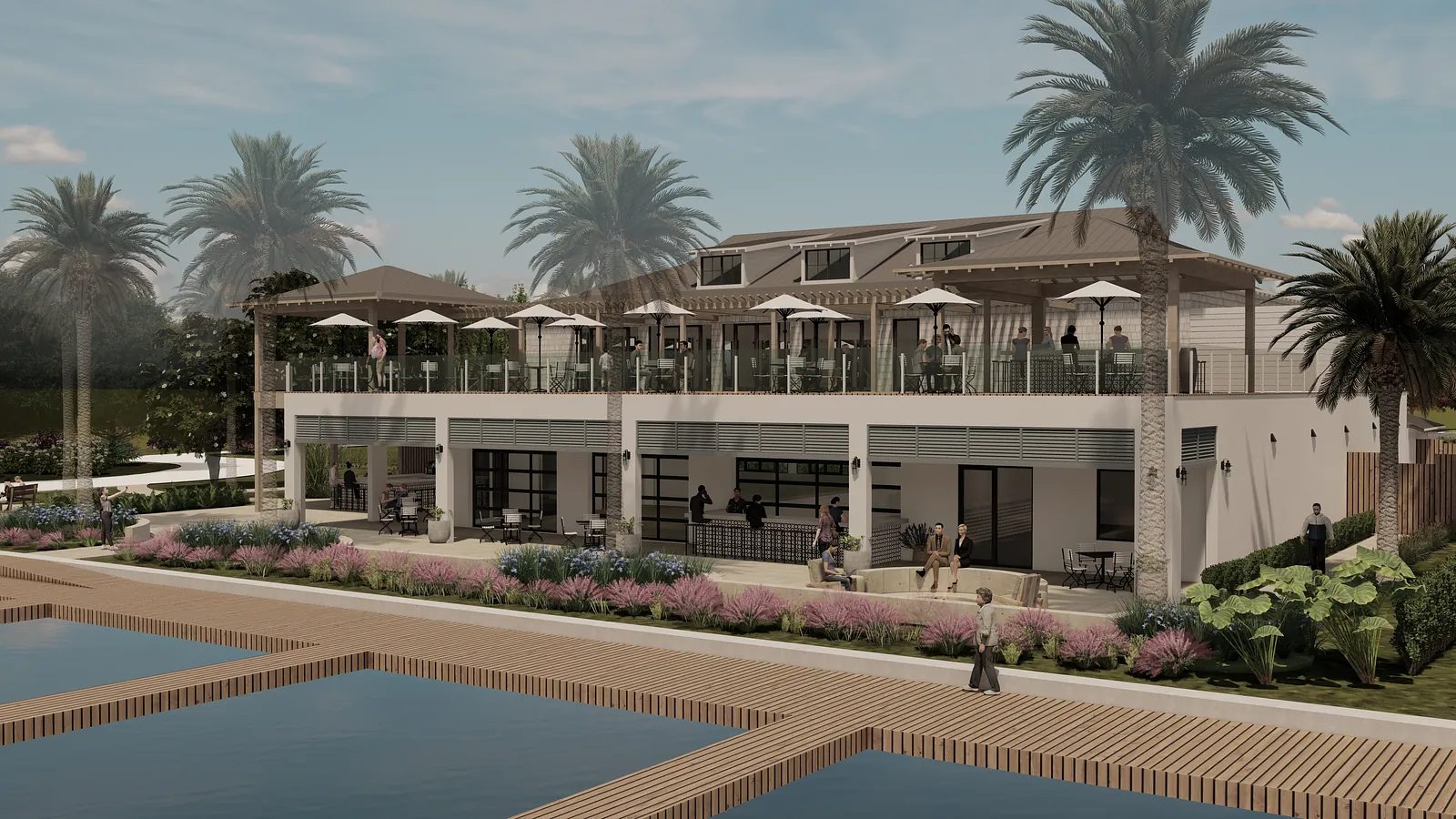 Exterior view of a two-story building with balcony, palm trees, seating areas, and pool.