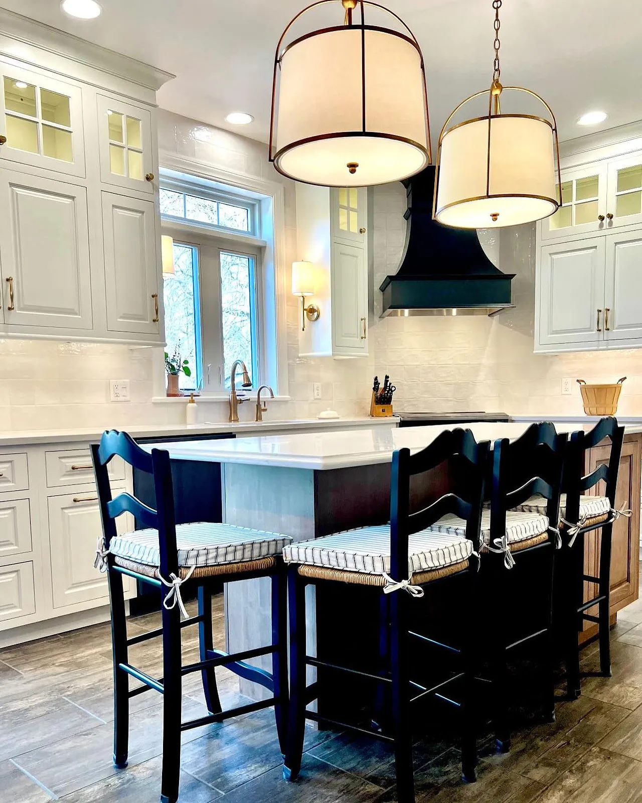 Dramatic pendant lights soften a French-inspired black and white kitchen