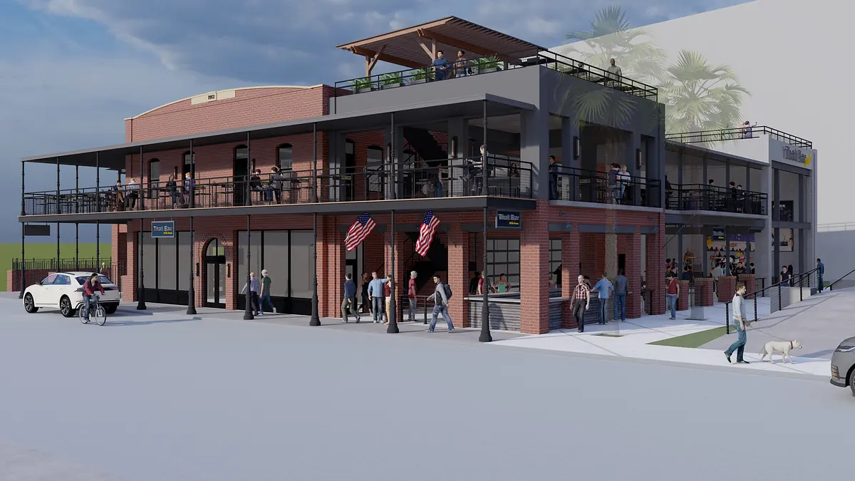 Multi-level building with red brick façade, balconies, outdoor seating, and surrounding pedestrians and vehicles.