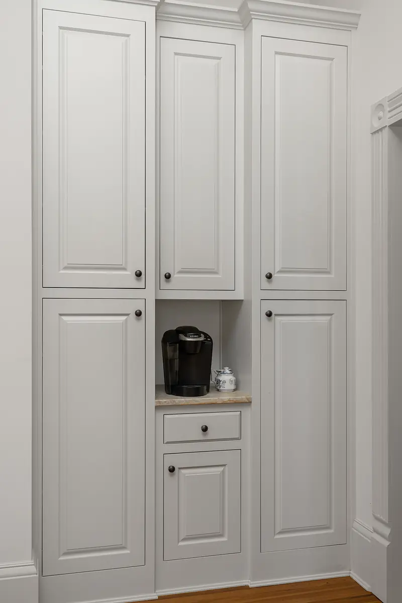 Space with white cabinets, coffee maker, and countertop between upper cabinets.