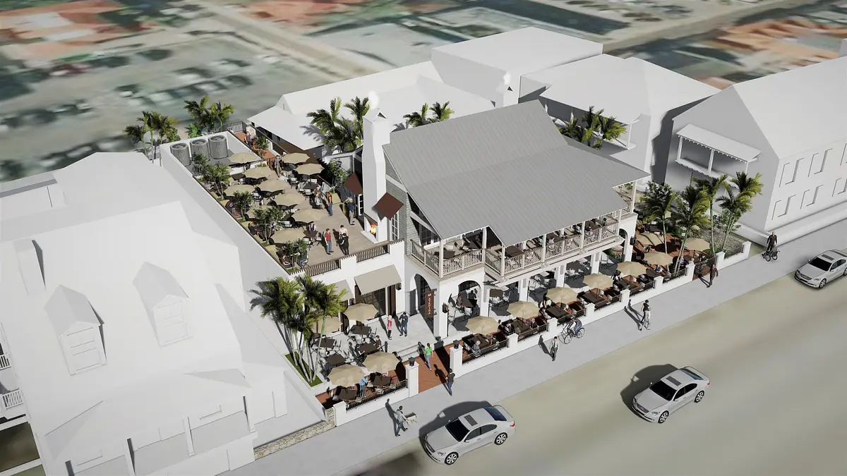 Outdoor dining area with tables, umbrellas, palm trees, and a two-story restaurant with a gabled roof.