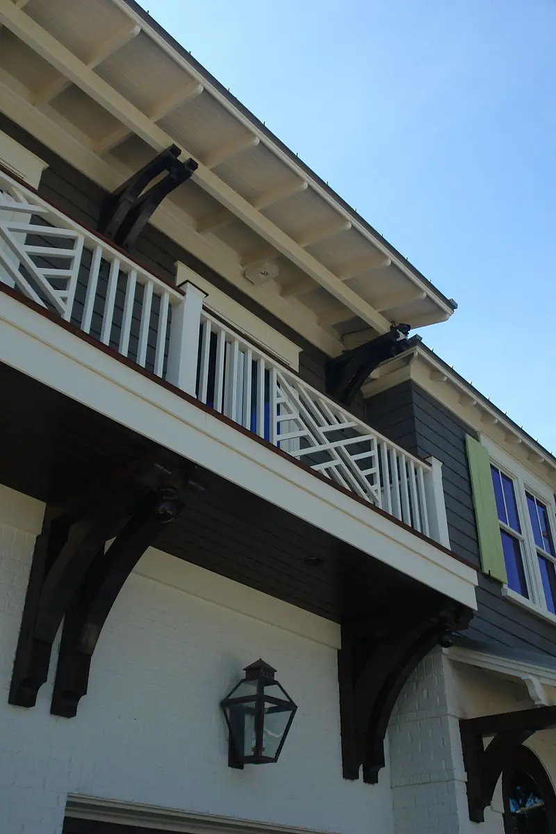 Exterior front view with balcony, gray siding, colorful window frames, and lantern fixture.