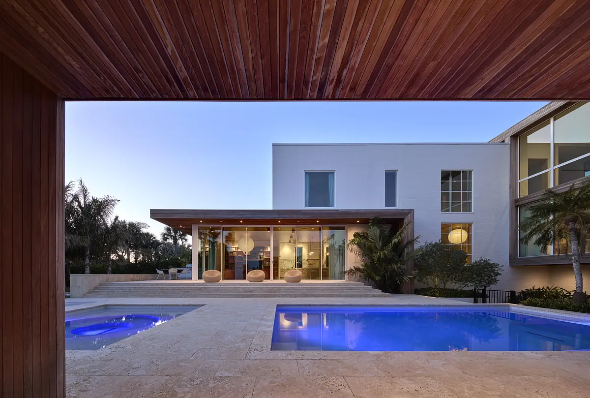 Exterior rear with swimming pool, lounge chairs, and wooden patio deck near a modern house.