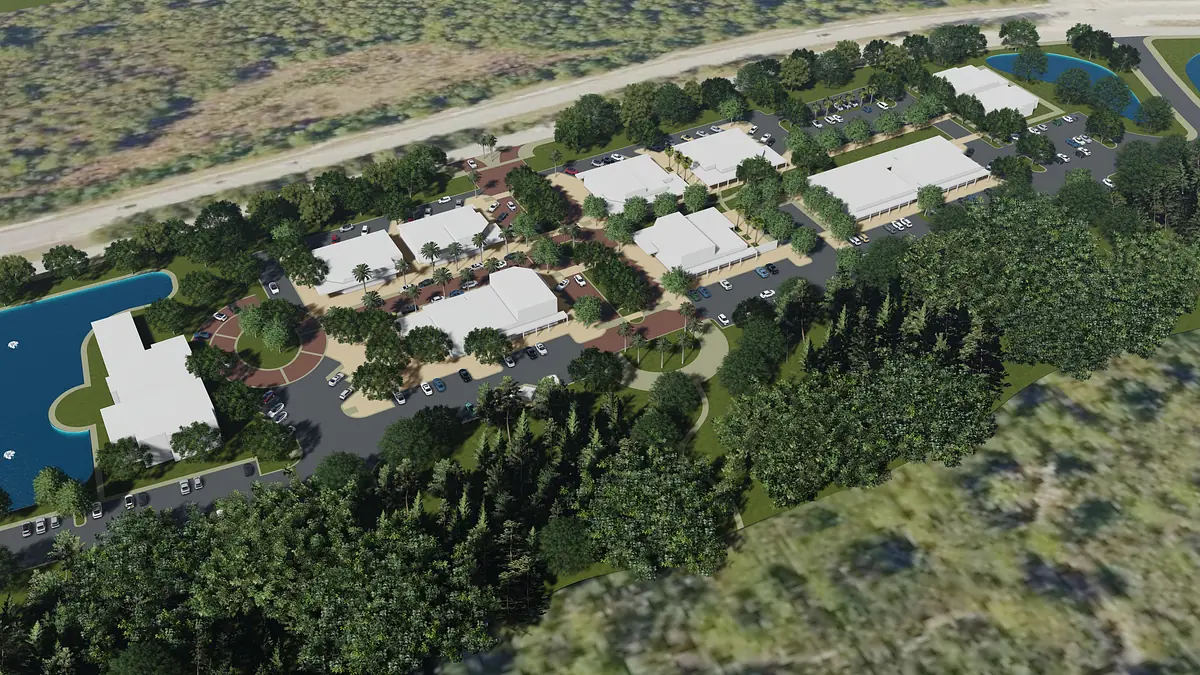 Aerial view of a residential complex with multiple buildings, trees, and a pond.