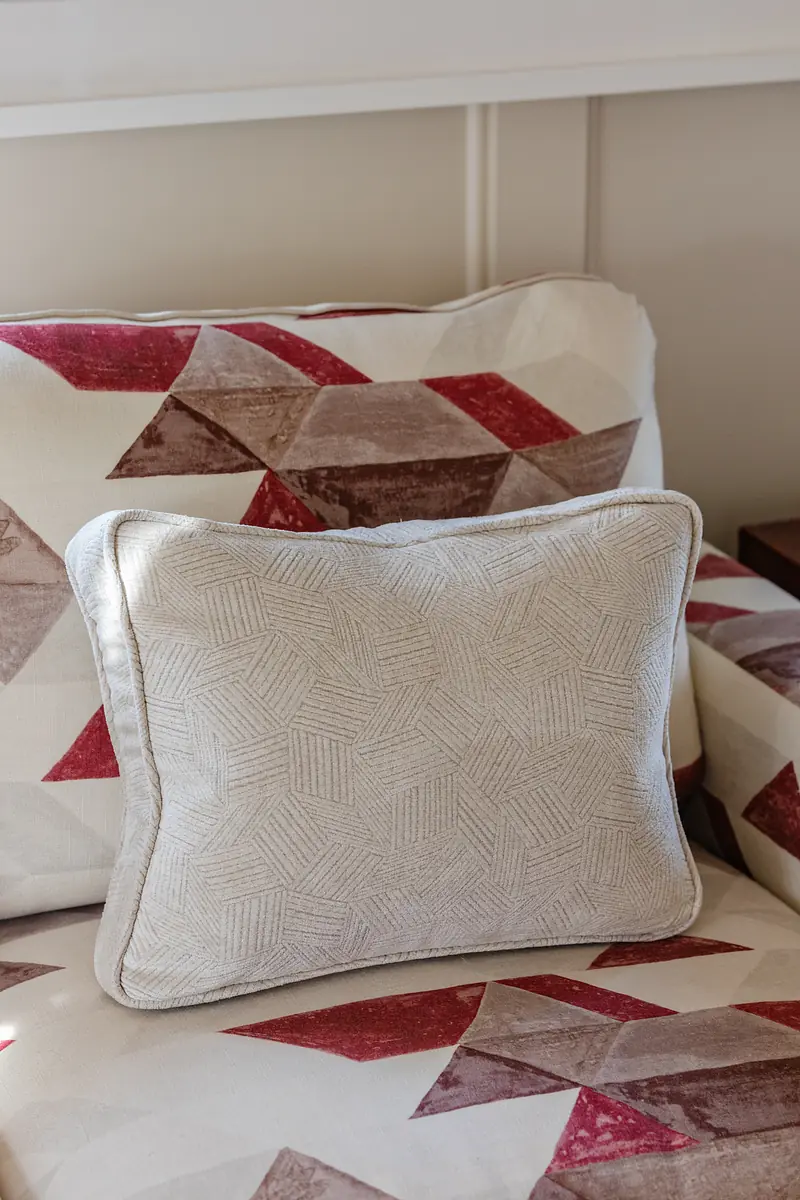 Close-up of a decorative pillow on a patterned couch with a geometric design.