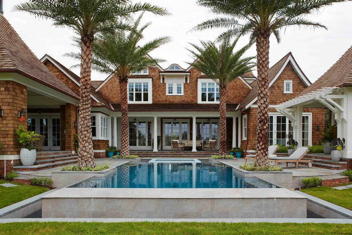 Exterior area with swimming pool, palm trees, lounge chairs, and garden space.