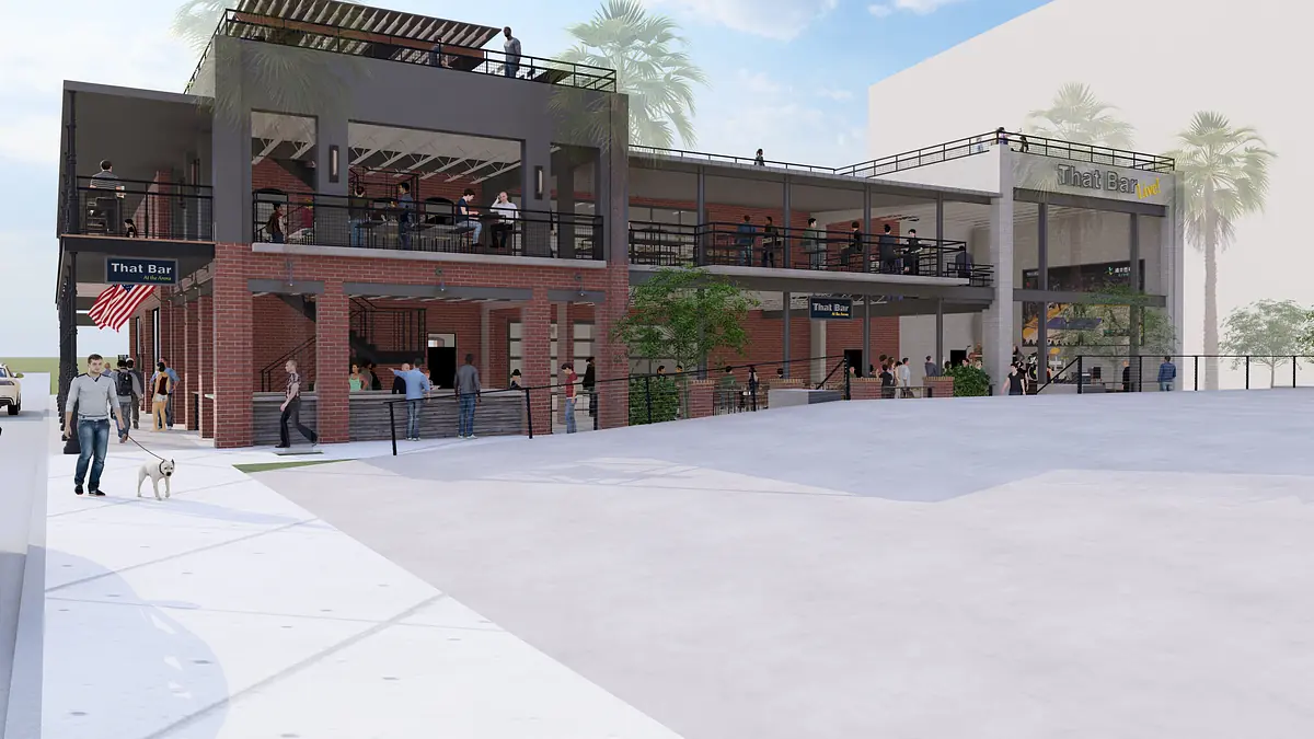 Exterior view of a two-story commercial building with brick and metal, glass windows, and outdoor seating.