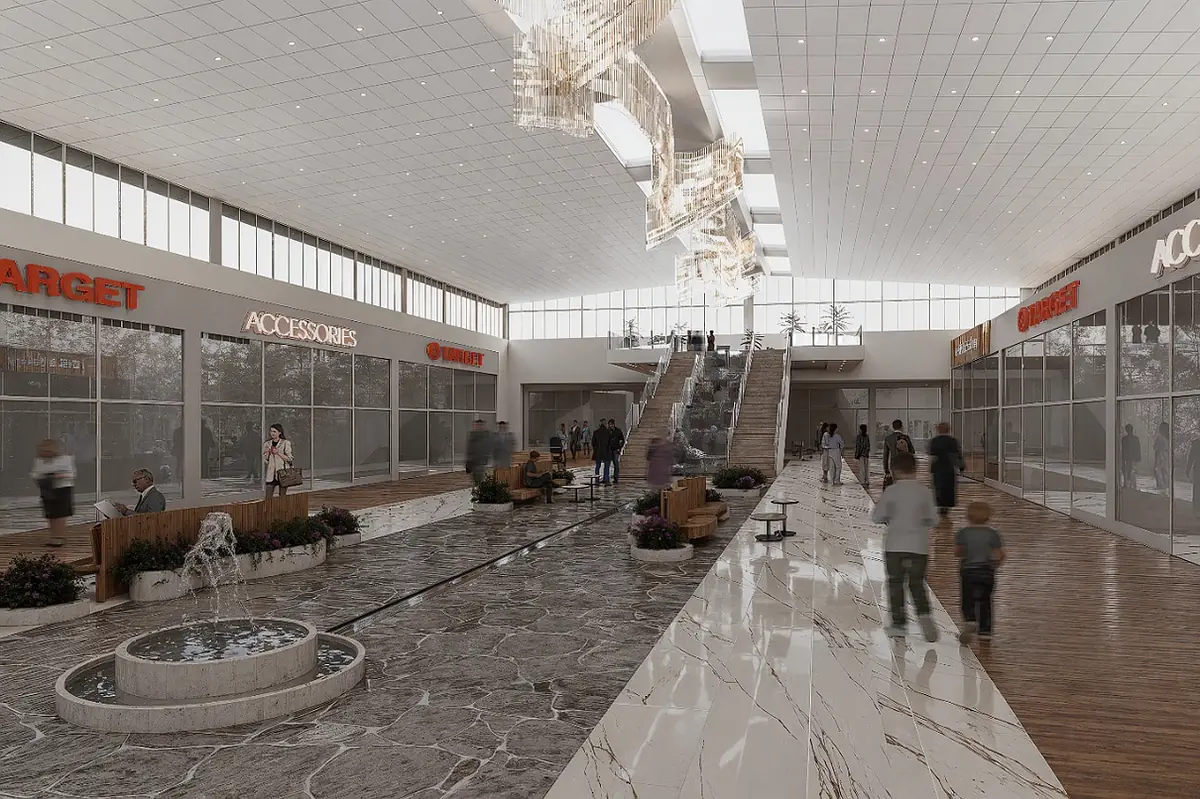 Open shopping area with storefronts, fountain, seating, staircase, planters, and decorative hanging fixtures.