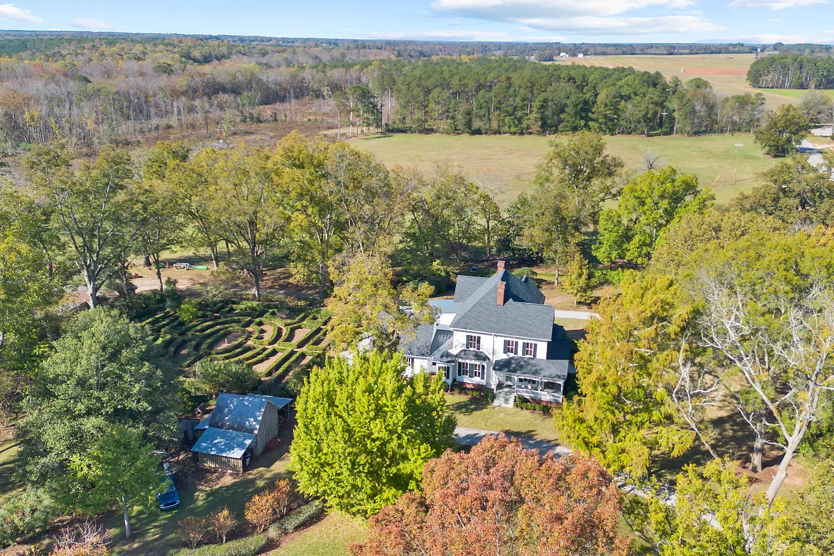 Aerial view of a house with lawn, trees, garden, and a shed.