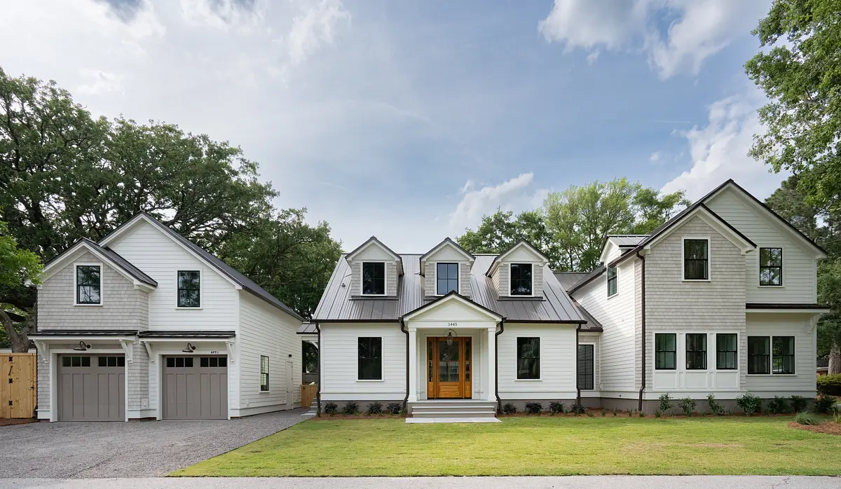 Exterior front of a house with double door entry, garage, gabled roof, and landscaped area.