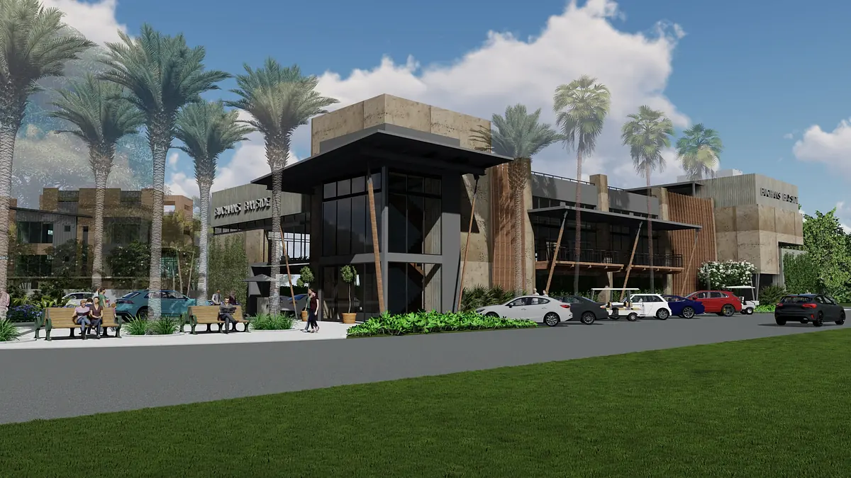 Exterior front view of a modern building with palm trees, benches, and cars in the parking lot.