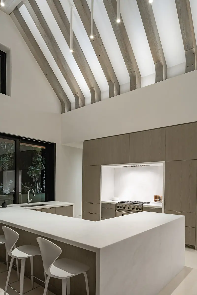 Kitchen with white island, gray cabinetry, stainless steel appliances, high ceiling, and large windows