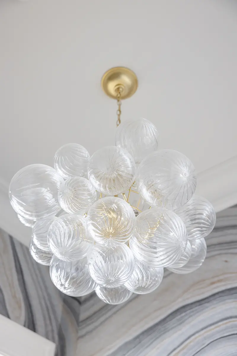 Ceiling light fixture with clear glass orbs arranged in a cluster with gold mount