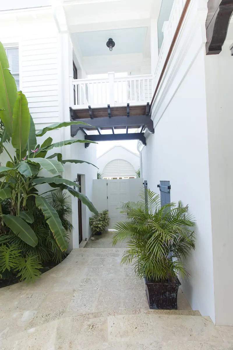 Patio with stone floor, large potted plants, and wooden overhang