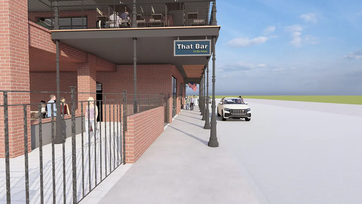Exterior front view of a bar with seating, brick walls, fence, and car parked on the street
