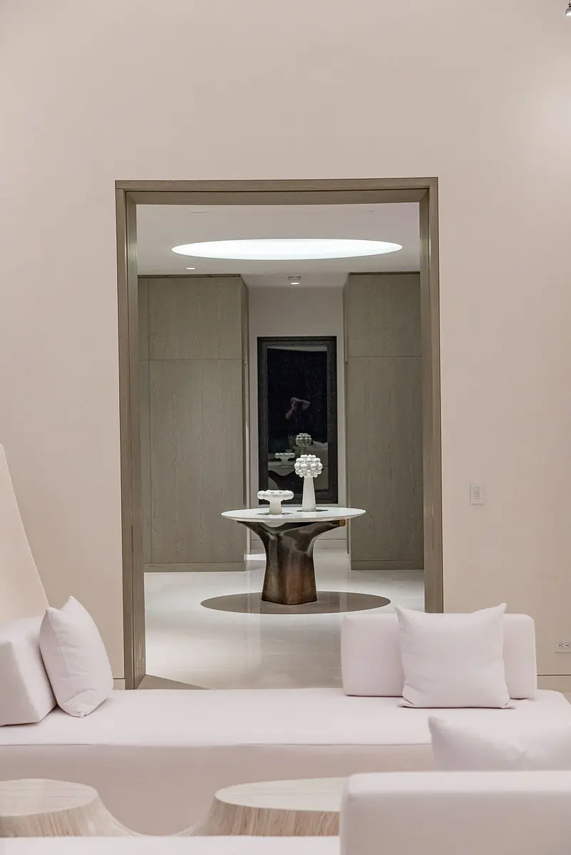 Living room with white sofa, round coffee table, and open doorway.