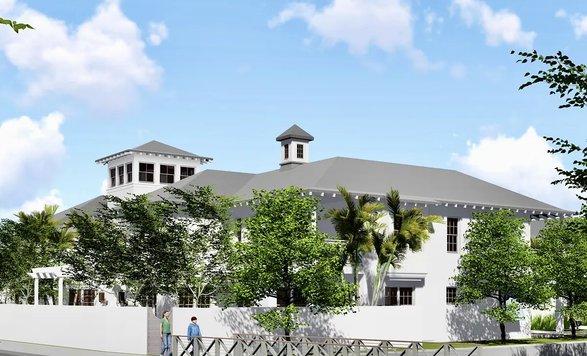 Exterior front view of a two-story building with gabled roof, windows, tower, and landscaped yard.