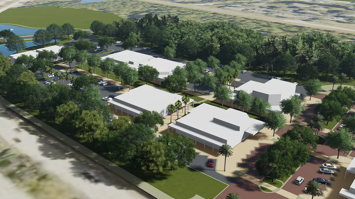 Aerial view of a commercial development with buildings, landscaping, parking, and a water body.