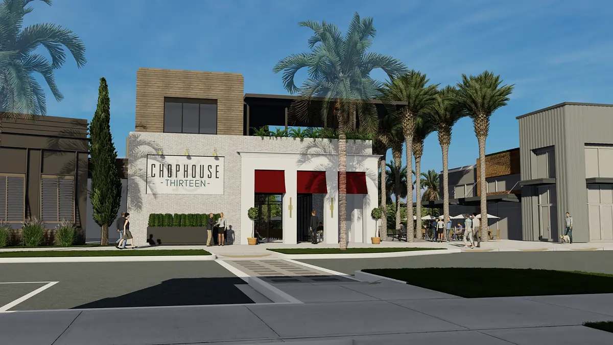 Exterior facade of Chophouse Thirteen with white masonry, red awnings, palm trees, and adjacent buildings.