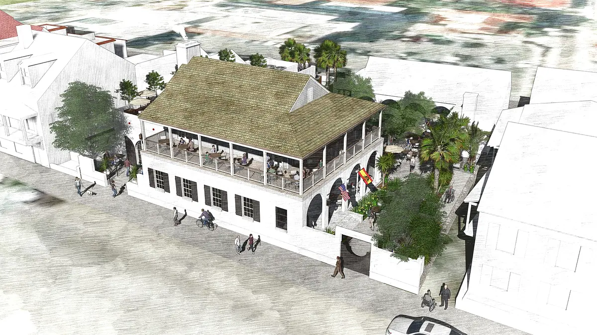 Exterior view of a building with large porch, tropical plants, and seating areas.