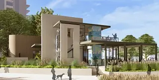 Exterior view of a contemporary building with glass panels, staircase, and surrounding landscaping.