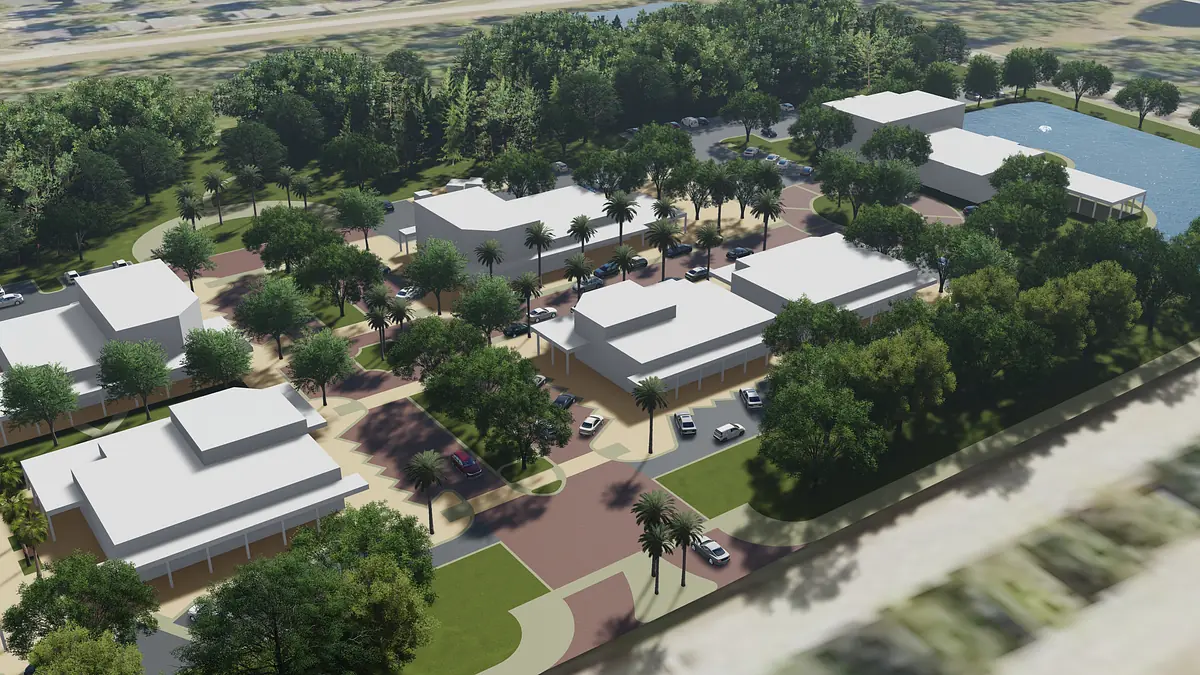 Aerial view of community development with buildings, pathways, trees, and a body of water.