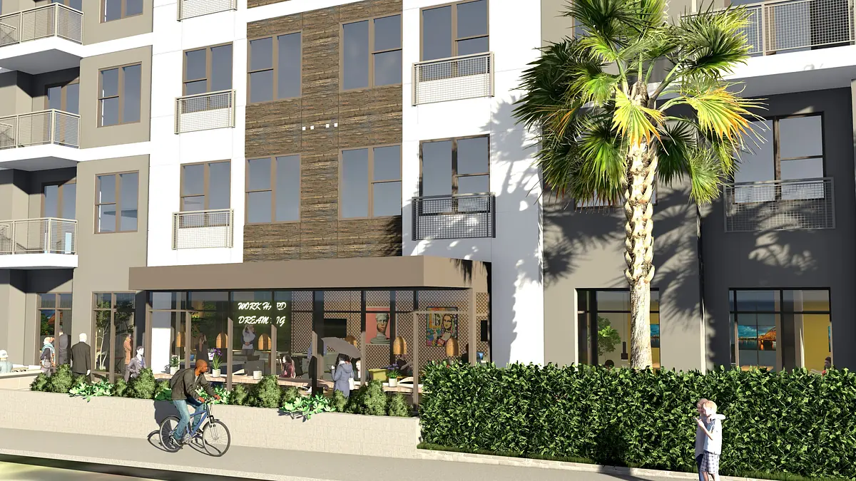 Front view of a multi-story building with large windows, balconies, storefront, and greenery.