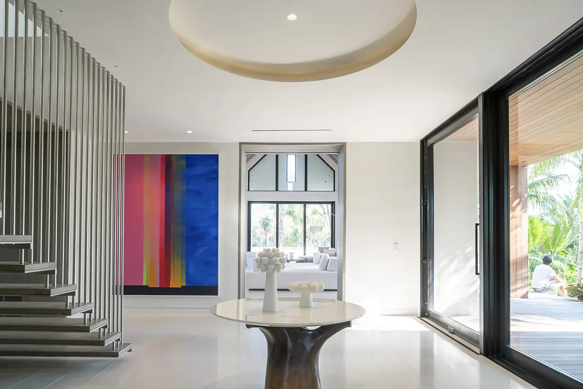 Foyer with circular ceiling, abstract artwork, round marble table, and glass sliding doors to outdoor area