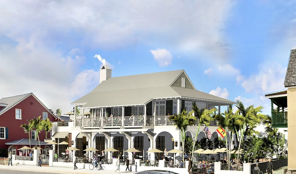 Exterior view of a two-story building with gray metal roof, columns, wraparound porch, and outdoor seating.