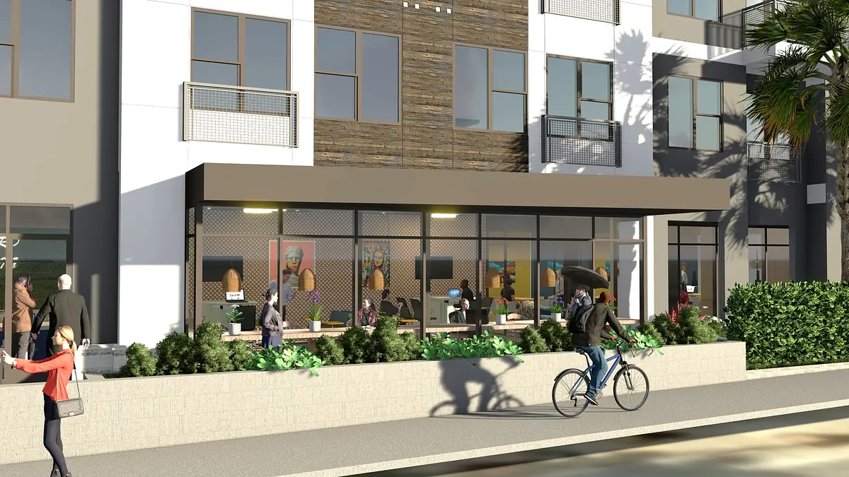 Exterior front view of a building with large windows, wooden accent wall, and seating areas with people outside.