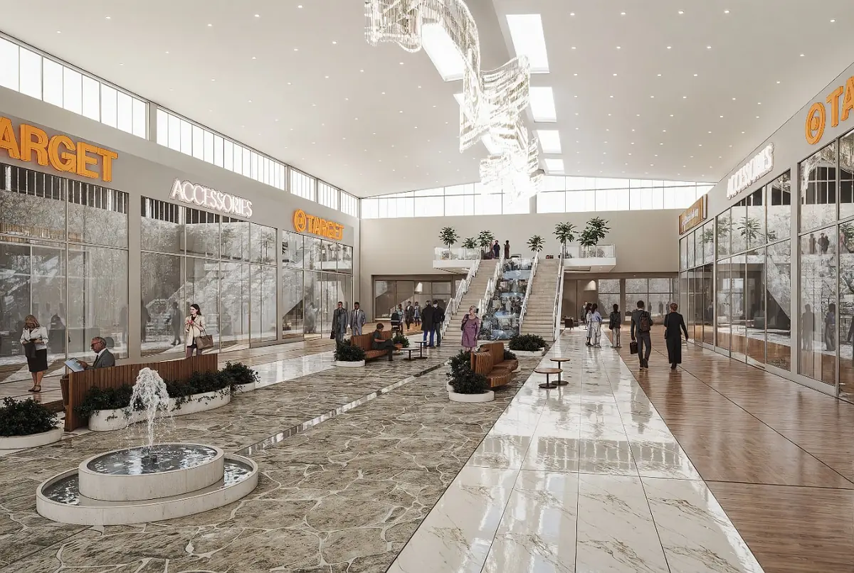 Indoor shopping area with fountain, escalators, shops, seating, plants, stone and wood flooring, and skylights