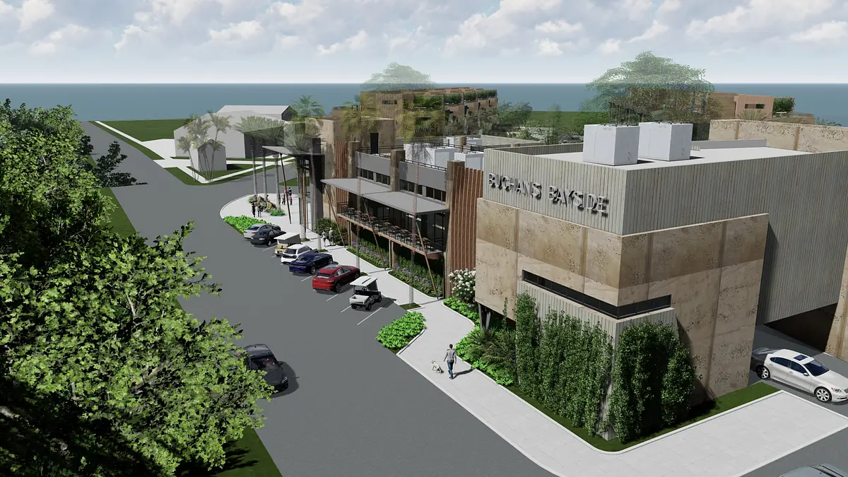 Exterior view of building with concrete facade, greenery, parking spaces, and large signage.