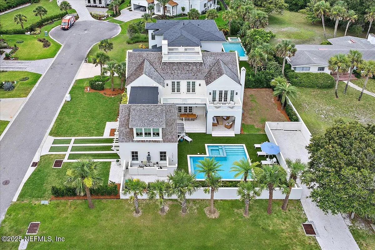 Exterior view of a two-story house with landscape, swimming pool, and balconies.