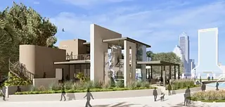 Modern building exterior with glass windows, textured walls, landscaping, and a staircase.