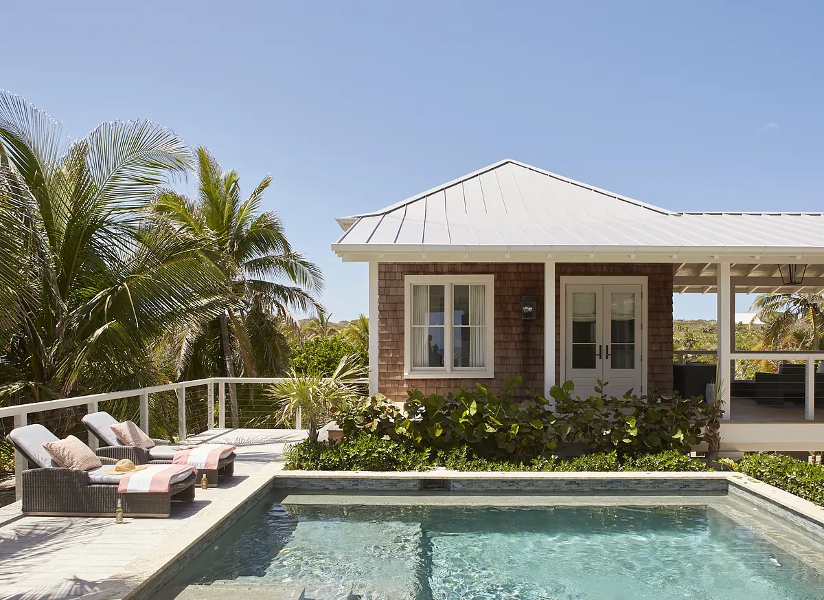 Exterior rear view with swimming pool, lounge chairs, shingle house facade, and landscaping