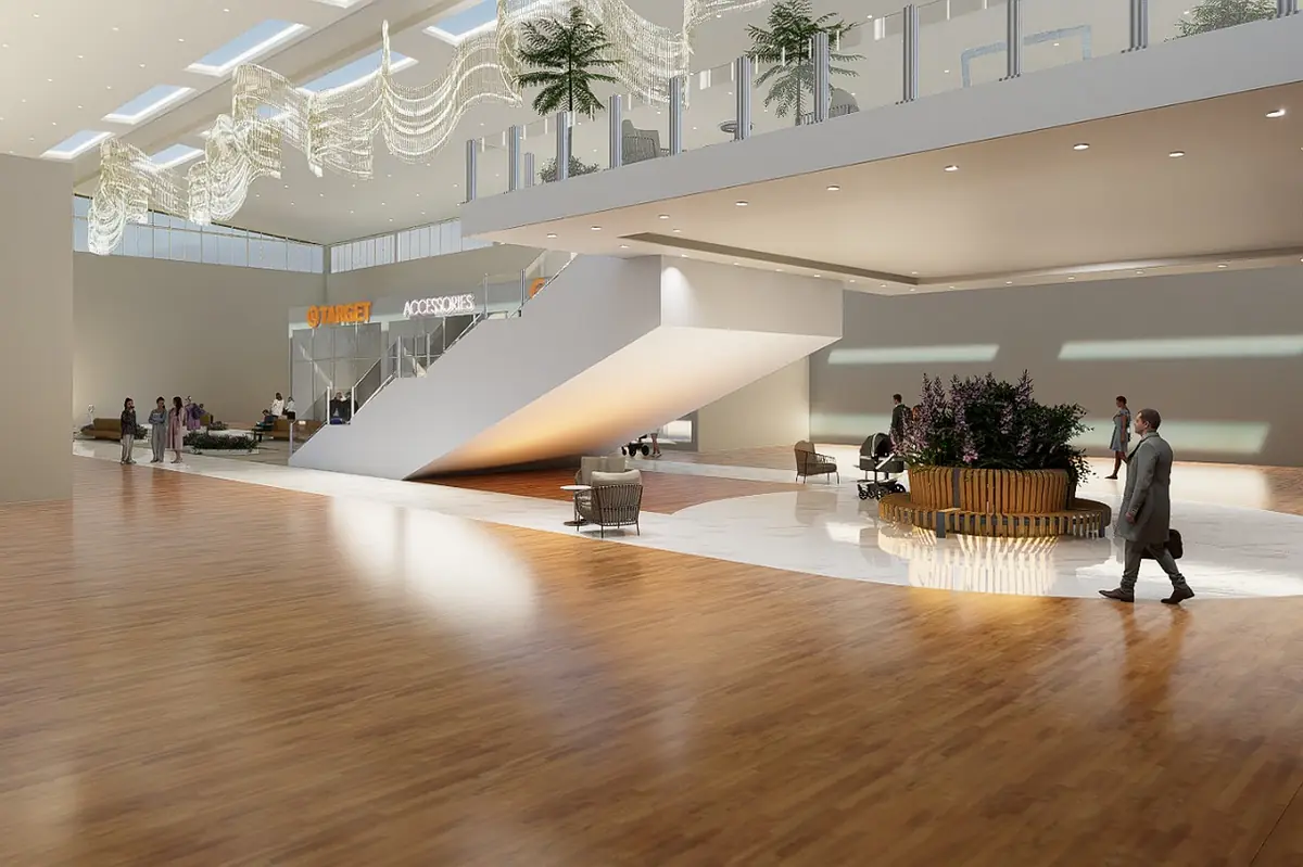 Spacious lobby with modern staircase, wooden flooring, seating arrangements, and indoor plants.