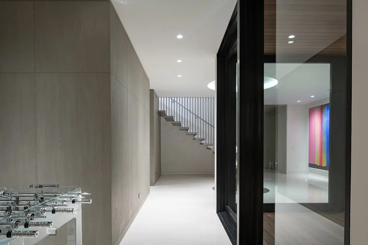 Foyer with staircase, glass door, textured walls, side table, and colorful artwork