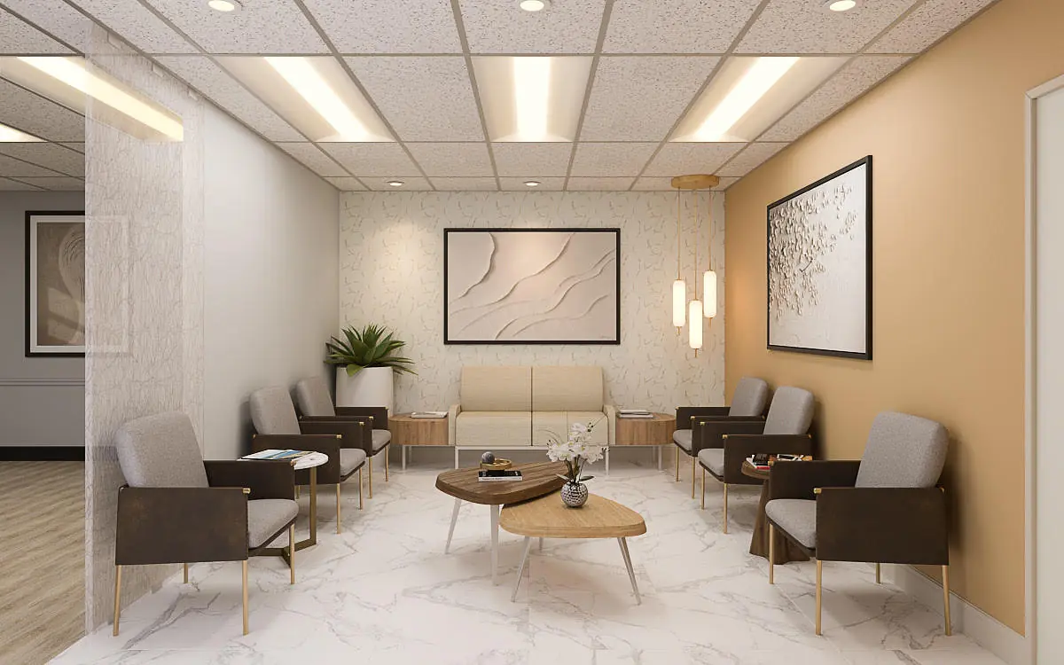 Waiting area with beige sofa, coffee tables, armchairs, wall art, plant, and decorative sconces.