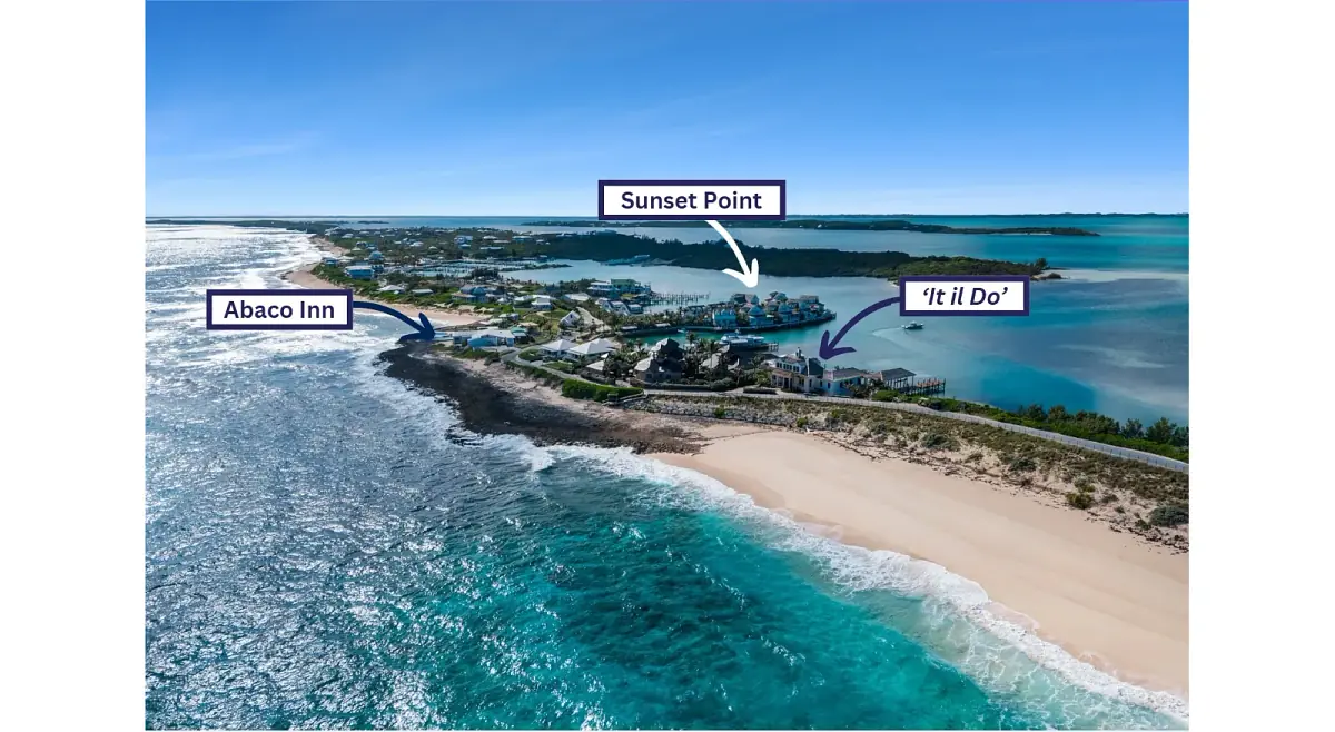 Aerial view of a coastal area with properties, sandy beach, clear waters, and labeled locations.