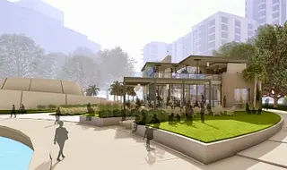 Modern building exterior with glass walls, pathways, and landscaped green areas.